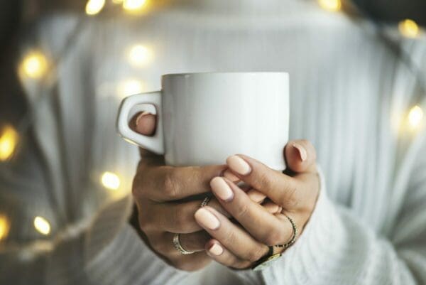 Woman's hands holding cup drink in a ceramic cup