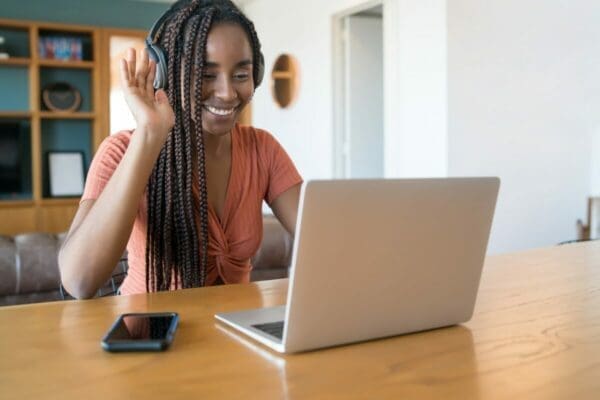 Female employee working from home with laptop and phone on her desk