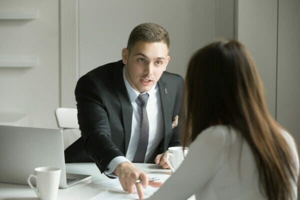 Young businessman is pointing to a mistake in a paper about Buyer Tactics in Negotiation