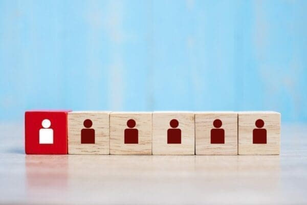 Red leader cube stands out from plain wooden cubes