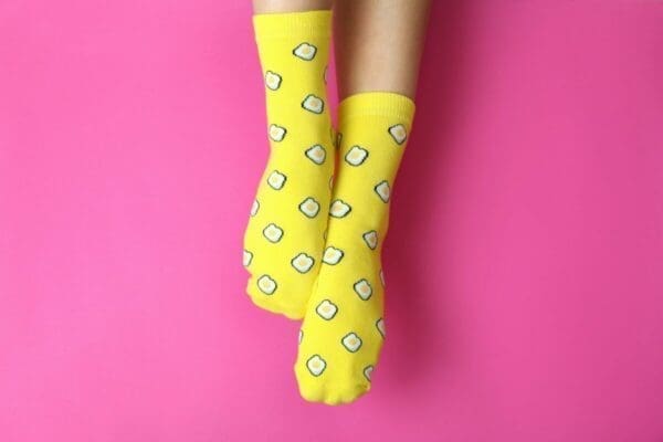 Female legs in funny socks on pink background