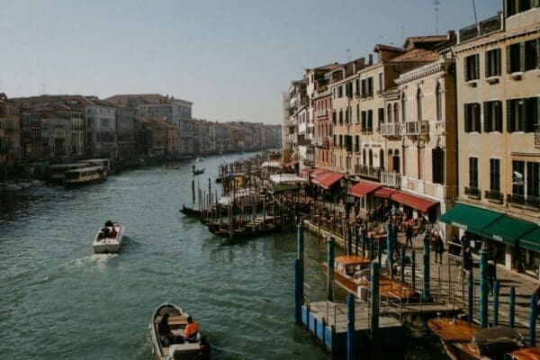 Houses and market stalls alongside a river in Italy