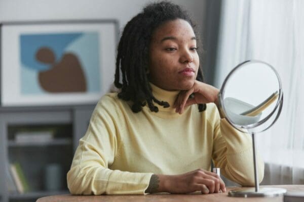 Work from home businesswoman at desk reflectig with a mirror