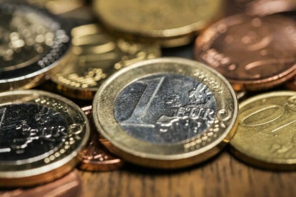 many euro coins laying on a wooden table