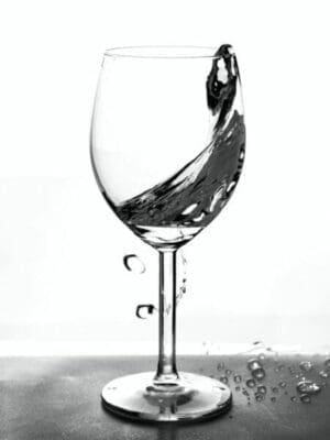 Half empty glass with water in motion