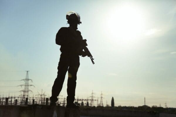 Silhouette of soldier against a blue sky background