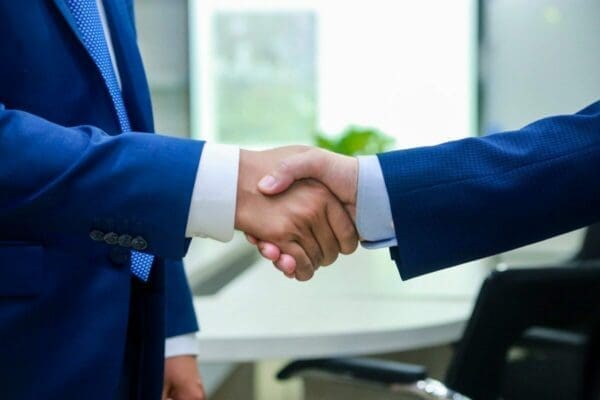 Negotiation handshake 2 businessmen shaking hands agreeing after a successful negotiation