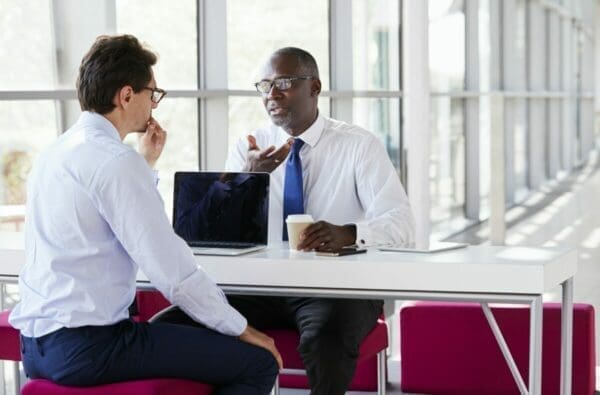 Two businessmen talk during a business meeting display communication skills
