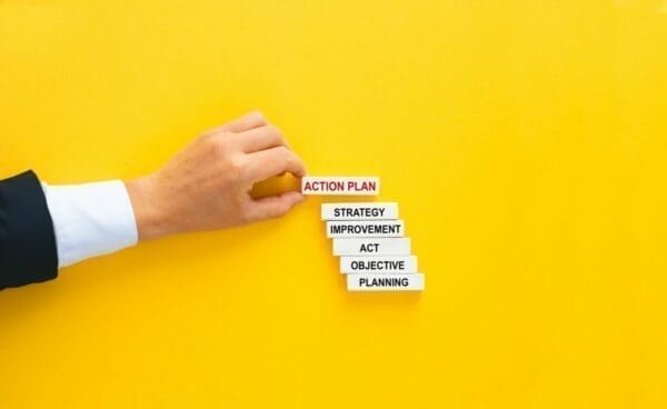 Businessman placing wooden block above other with words on