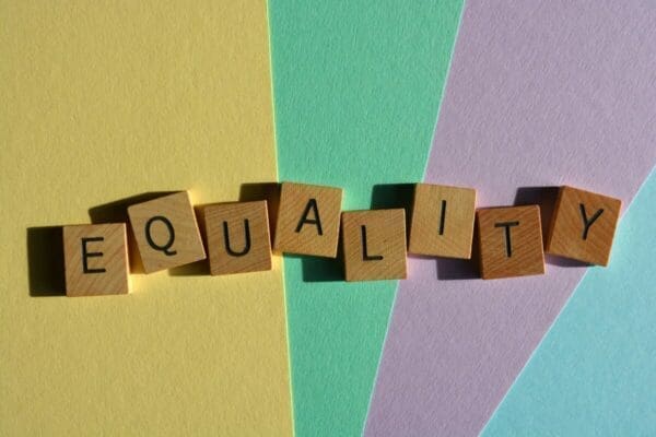 Equality spelled with wooden blocks on colourful rainbow background