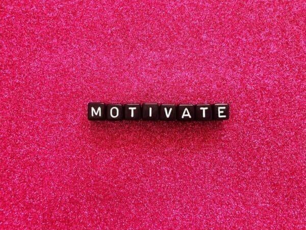 Motivate spelled by black cubes on pink background