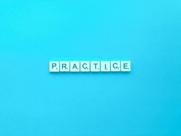 Practice spelled with word scramble cubes on a blue background