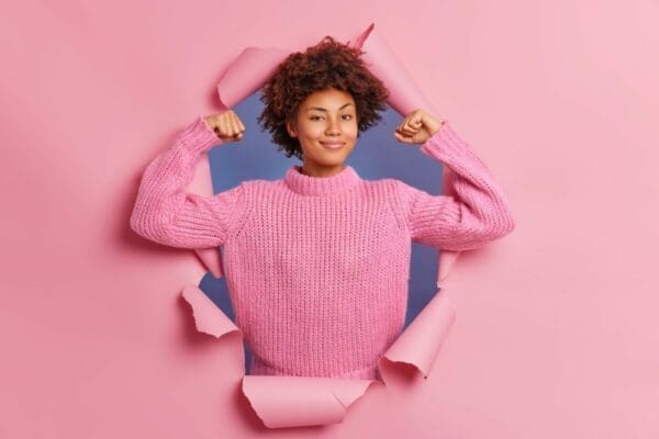 ENTJ Woman tearing through paper showing strength in arms