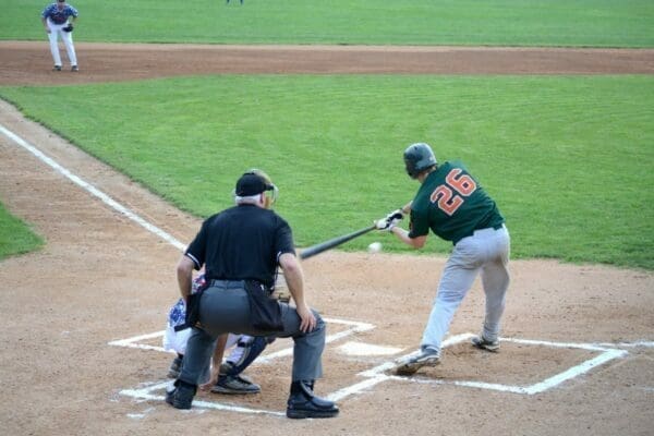 Minor league baseball team with batter hitting the ball a bat