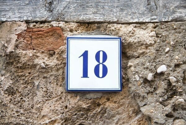 Number eighteen on the grey stone wall