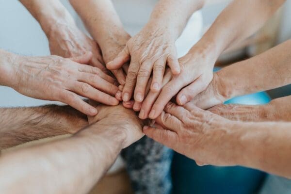 Team hand huddling to resolve conflict and build stronger team