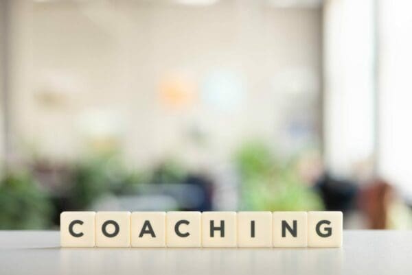 Coaching spelled with wooden cubes with blurred background