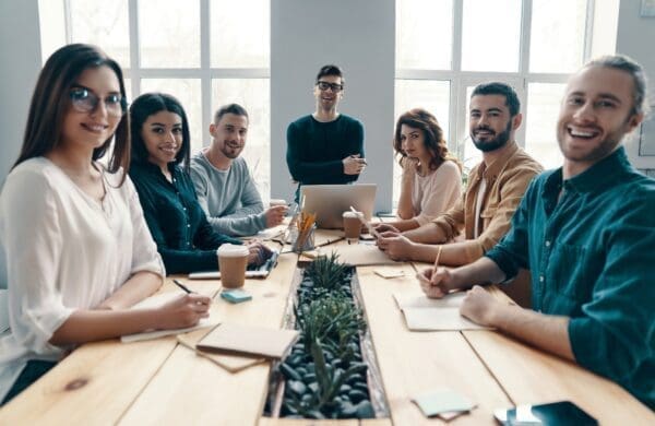 Dream team of happy smiling employees around a table