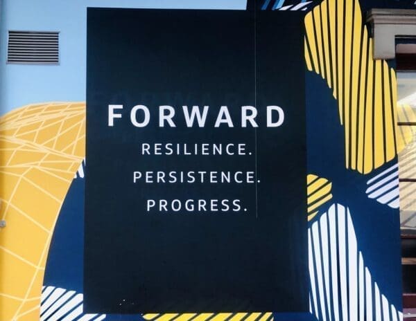 Motivating public mural painted on a building says forward resilience persistence prgress