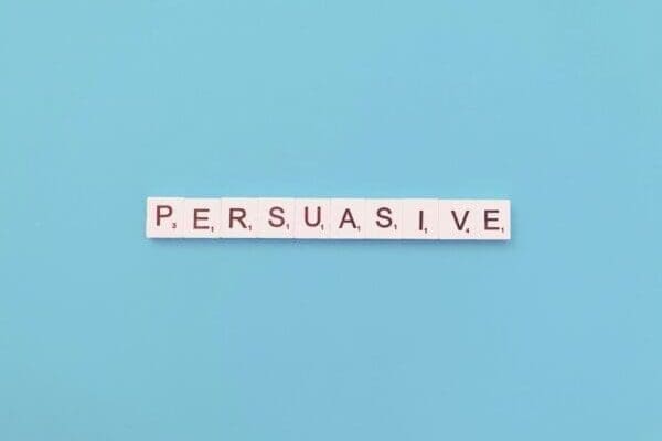 persuasive spelled with white word scramble cubes on light blue background