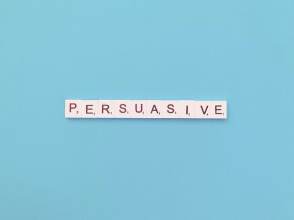 Persuasive spelt out in scrabble tiles on a blue background