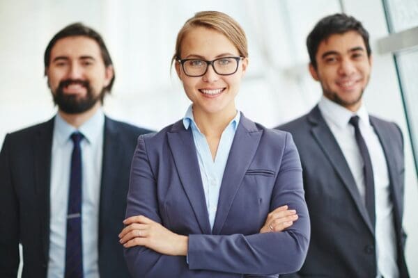 female leader in front of two businessmen smiling about how to choose a leadership pattern