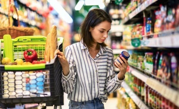 Young woman with shopping in a supermarket benefiting from a planogram