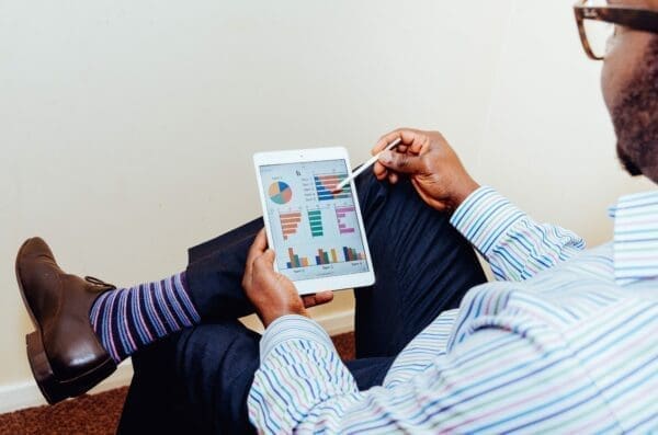 Office man holding tablet with charts on screen analyzing management communication effectiveness