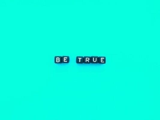 Be true spelled with black cubes on a blue background