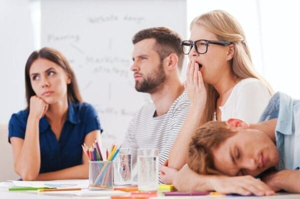 Bored colleagues during a boring presentation yawning and sleeping