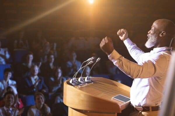 Businessman standing at podium and giving speech 