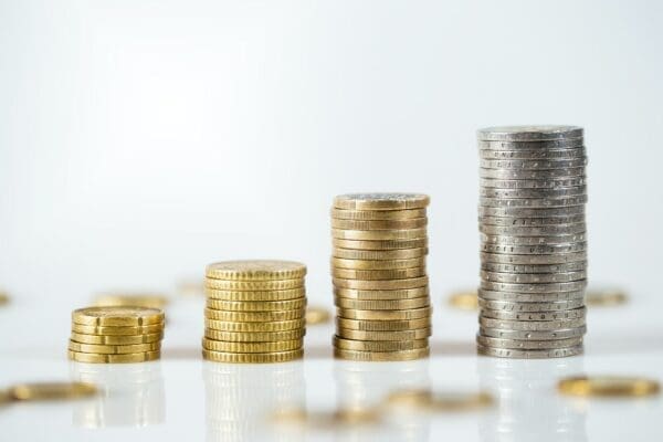 Four piles of gold and silver coins on table