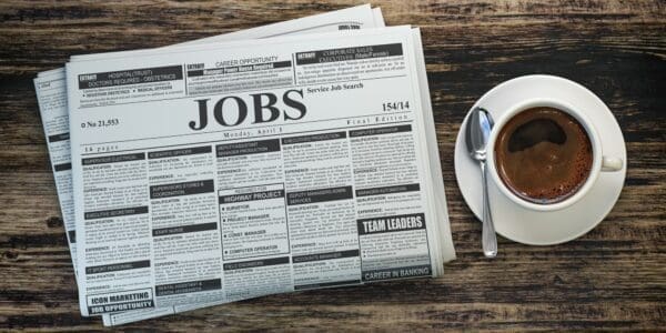 Job classifieds ads newspaper and coffee cup on wooden table