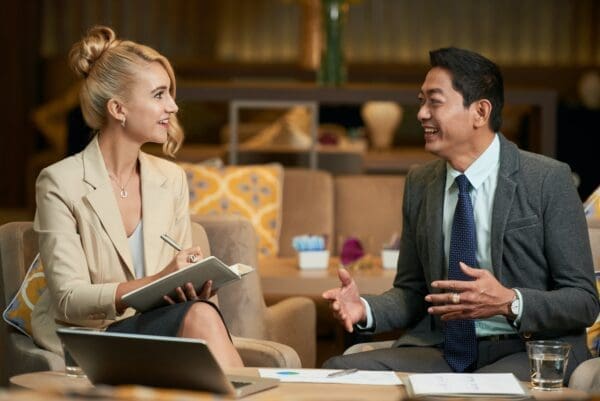 Businessman and businesswoman talking on a sofa