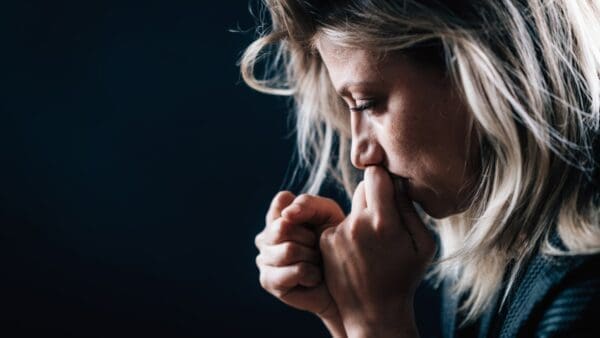 Close up of a woman looking down and crying