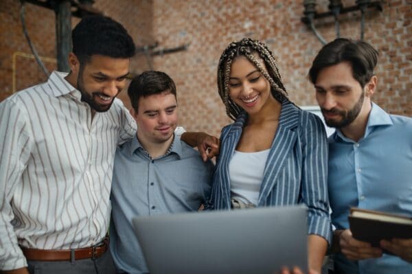 Group of work colleagues looking at a laptop