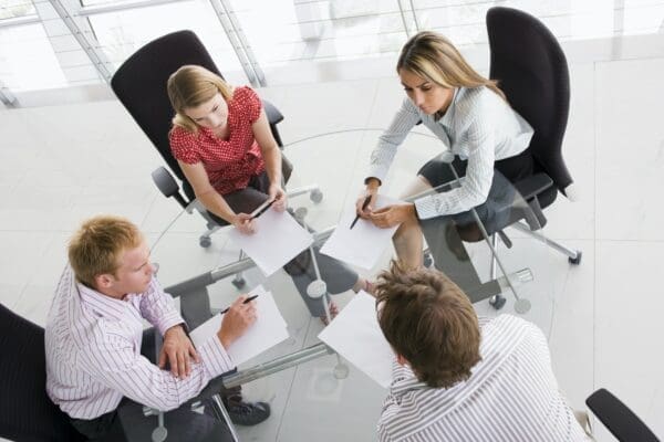 Four businesspeople in a boardroom with paperwork