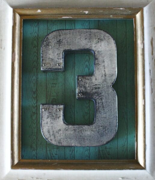 Framed metal number three with dark green background