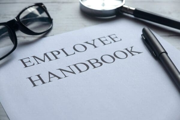 Close up of employee handbook with pen and glasses next to it