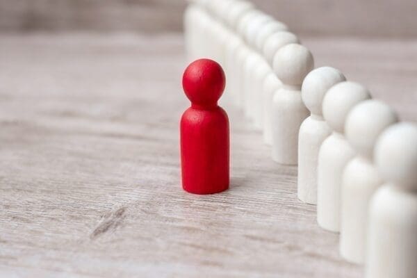 Red leader figure next to a line of followers figure