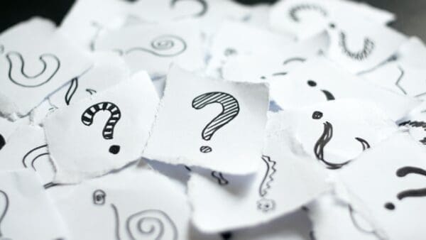 Question mark doodles on scraps of paper