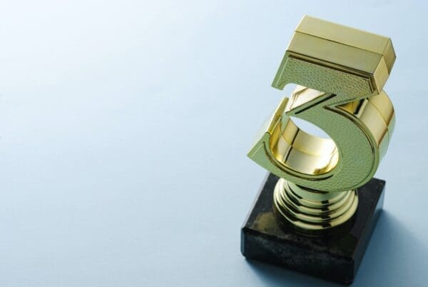 Number three Number three gold trophy on a blue surface