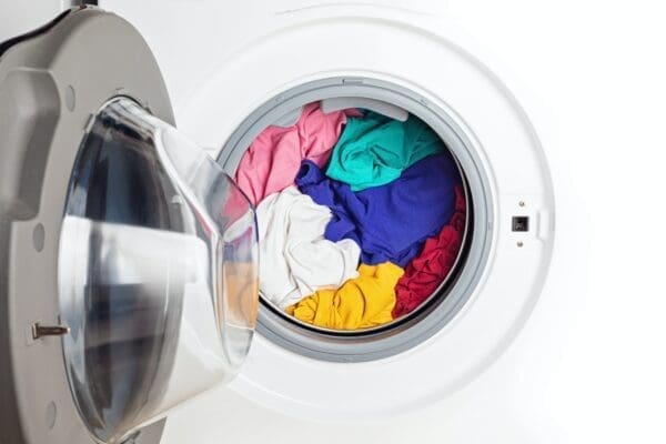 Washing or drying machine loaded with the colourful laundry