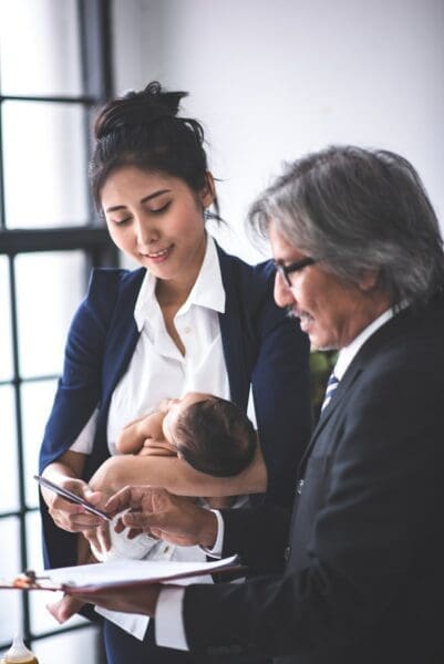 Working mother new mother businesswoman is working and holding her baby