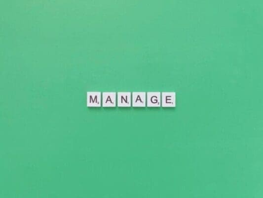 Manage spelled with word scramble cubes on a green background 