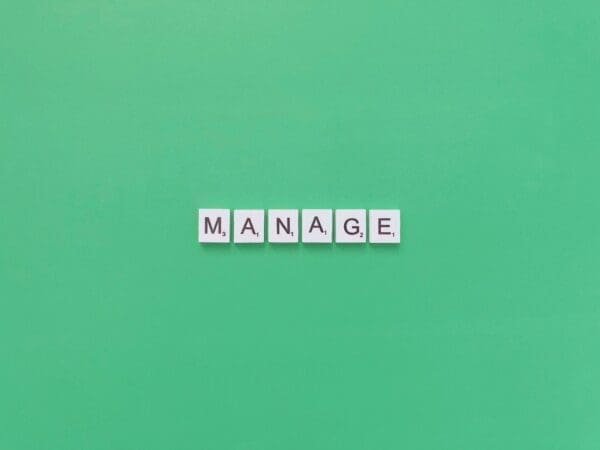 manage Manage spelled with word scramble cubes on a green background