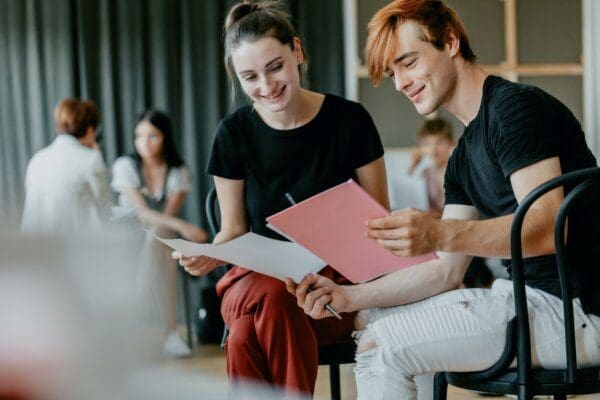 Man and woman reading two business scripts together