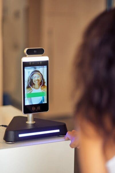 Female worker using face recognition at a UK grocery store