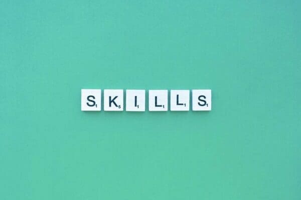 Skills spelled with white letter tiles on blue background