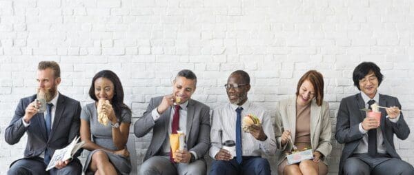 Diverse work team eating lunch on a bench